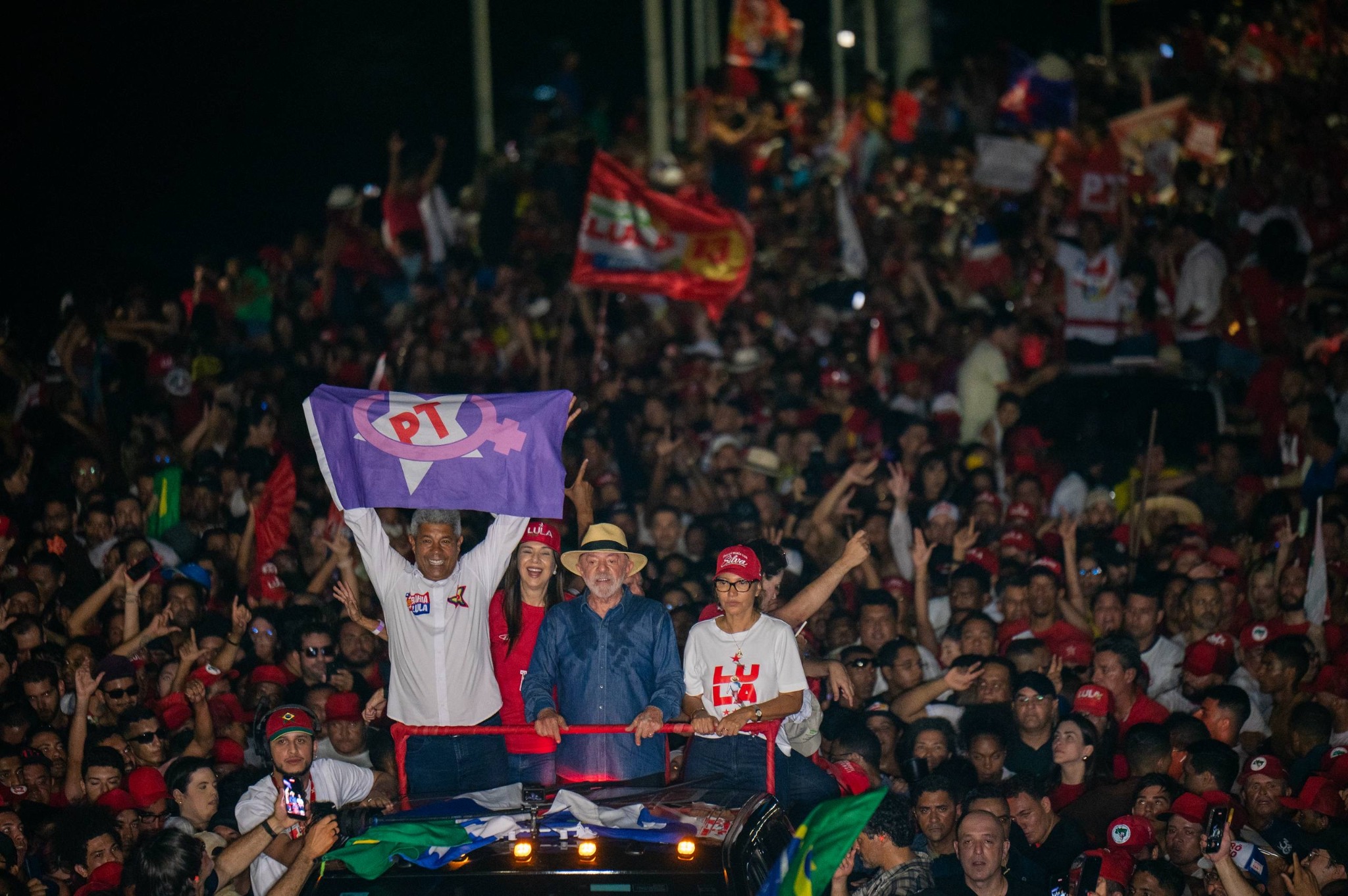 Lula em ato público, cercado por apoiadores e bandeiras