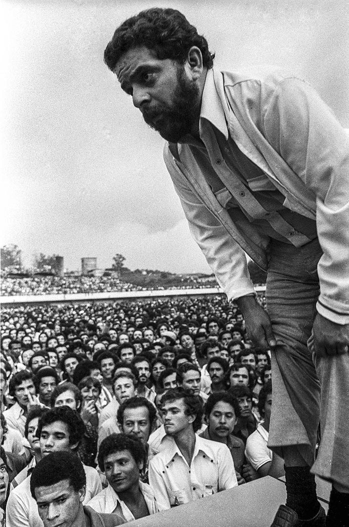 Registro em preto e branco de Lula diante de uma assembleia de trabalhadores