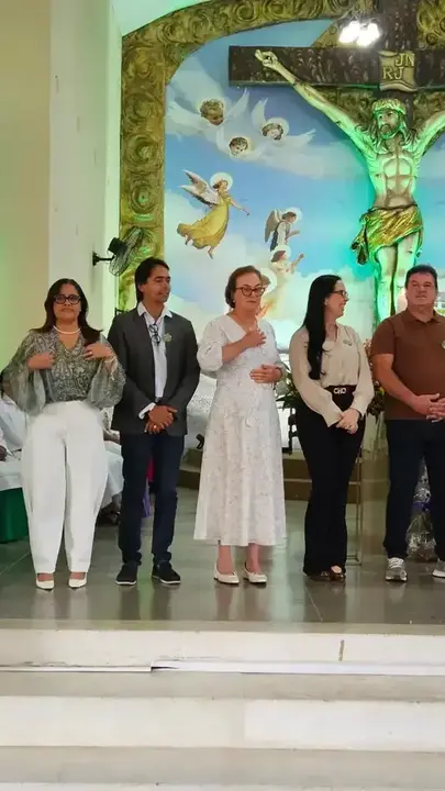Neusa ao lado de participantes diante do altar