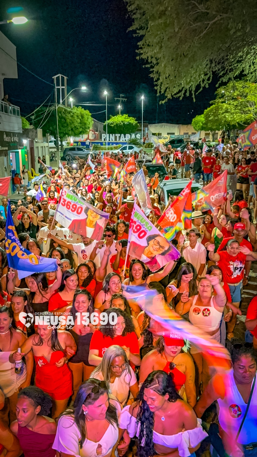 Multidão com bandeiras durante a caminhada noturna em Pintadas