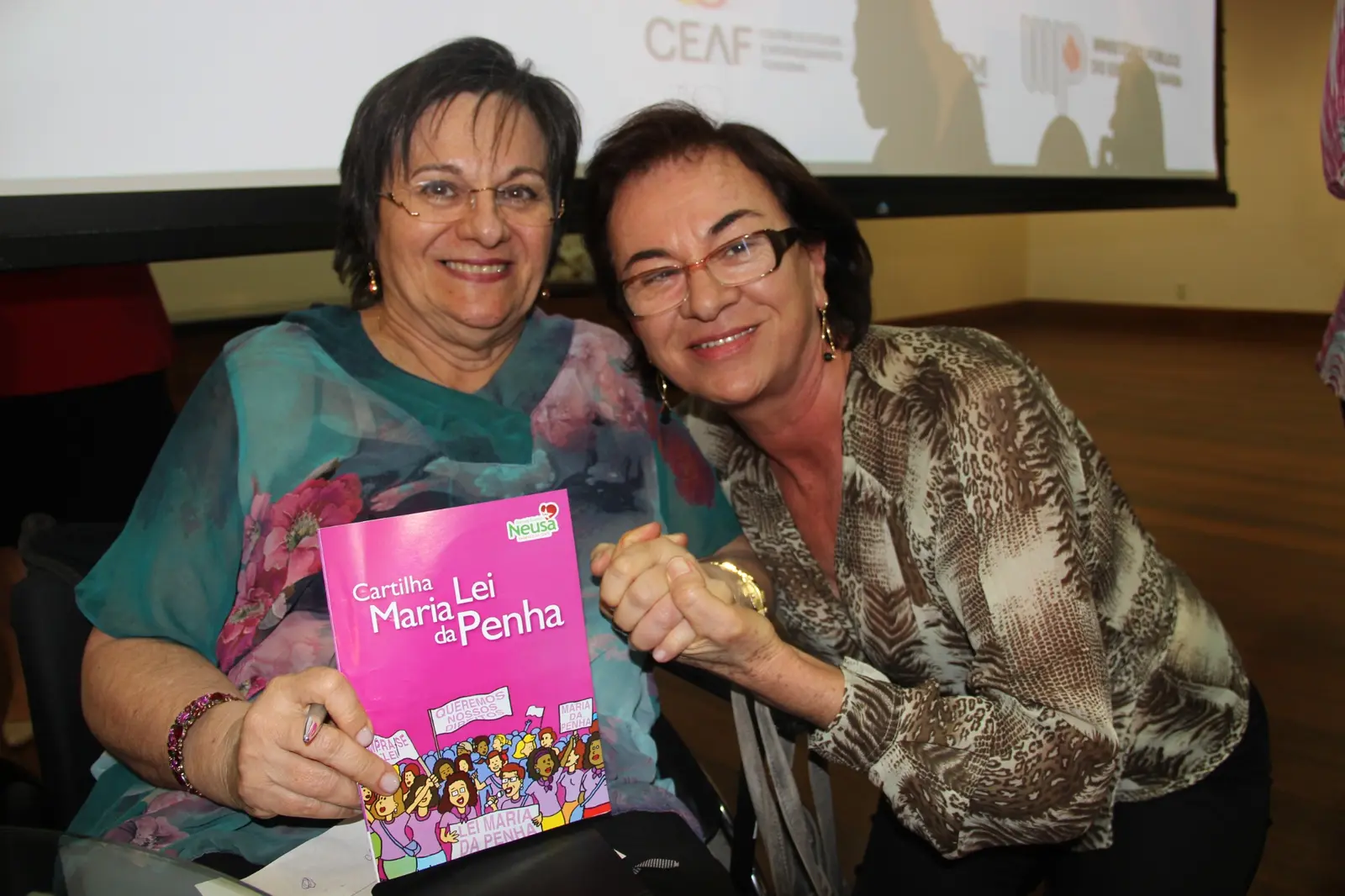 Maria da Penha e Neusa Cadore juntas com a cartilha do Mandato da Gente